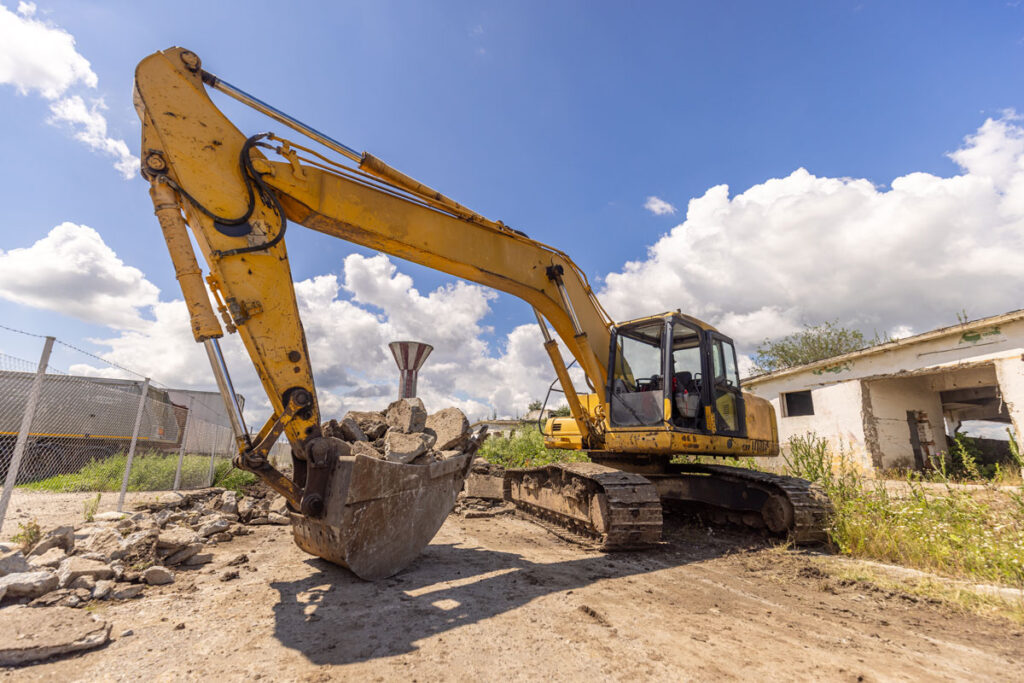 Excavator breaking ground at the start of new home construction